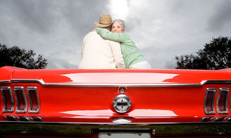 older couple sitting on sports car