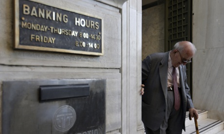 A man leaves a branch of the National Bank of Greece in Athens today.