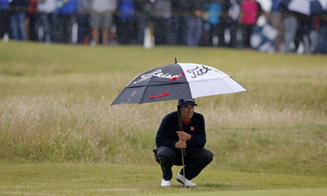 Adam Scott shelters from the rain, he is slipping out of contention.