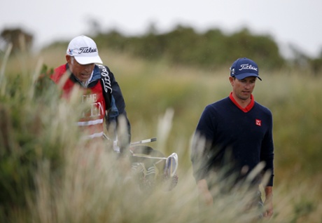 Adam Scott walks with his caddie, he dropped five shots in the final five.