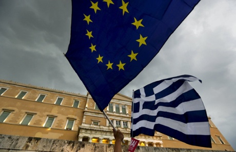 Protesters wave Greek and EU flags during a pro-Euro rally in front of the parliament building.