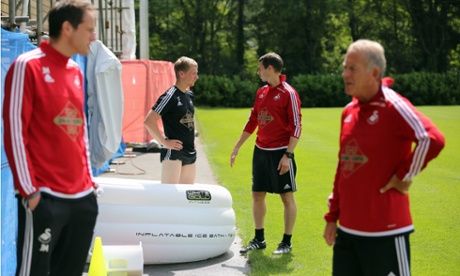 The left-back Stephen Kingsley stands in an inflatable ice bath at Swansea's training ground.