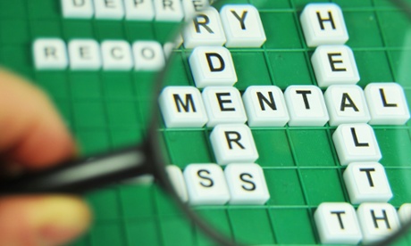 Scrabble board with magnifying glass showing the word mental in focus