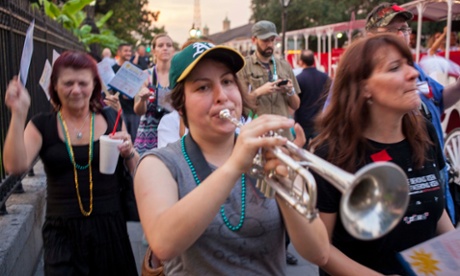 Karissa McKelvey plays the trumpet as Strike Debt members march through New Orleans