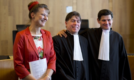 Urgenda Foundation director Marjan Minnesma, left, and lawyers Koos van der Berg, center, and Roger Cox, right, pose for pictures after a Dutch court ordered the government to cut the country's greenhouse gas emissions by at least 25 percent by 2020 in a groundbreaking climate case that activists hope will set a worldwide precedent in The Hague, Netherlands, Wednesday, June 24, 2015. The Hague District Court made the ruling Wednesday in a case brought by a sustainability organization on behalf of some 900 citizens, claiming that the the government has a duty of care to protect its citizens against looming dangers. (AP Photo/Peter Dejong)