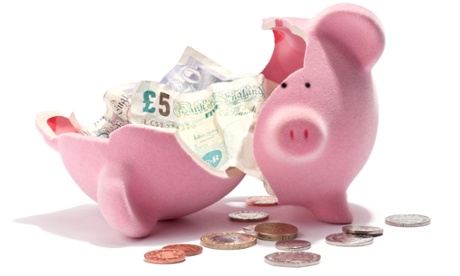 A broken piggy bank and British bank notes