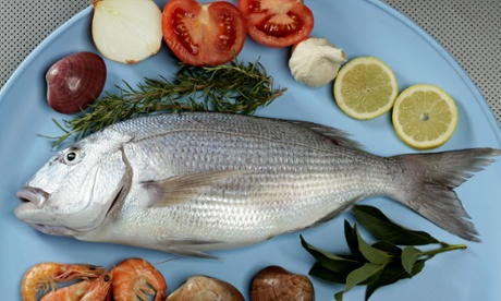 A fish on a plate with accoutrements.