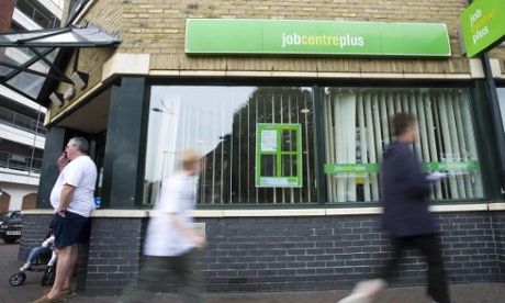 Job seekers walk past a job centre