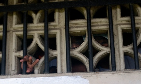 Hand reaching through window with bars on it