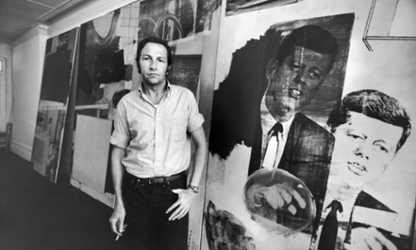 Artist Robert Rauschenberg standing in front of his painting of President John Kennedy.