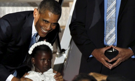 Barack Obama poses for a photo with a girl after receiving flowers from her upon arrival.