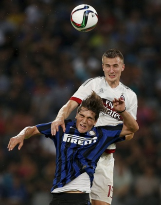 AC Milan's Rodrigo Ely gets the better of Inter Milan's Razvan Popa during their aerial duel.