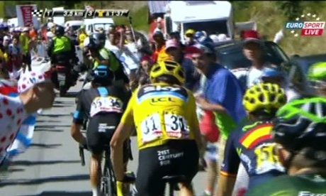 A 'fan' leans in and spits on Chris Froome during stage 20 on Alpe d'Huez.