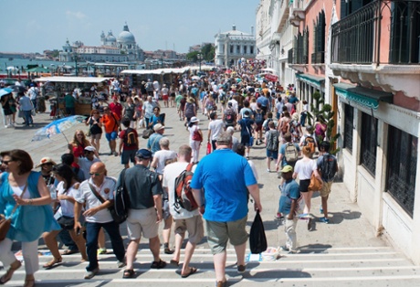 Tourists walk on the bank heading towards Saint Mark's Square in Venice.