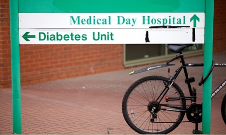 A sign outside a hospital entrance directing visitors to various departments