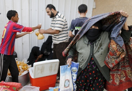 An elderly woman leaves a charity food assistance centre after receiving her ration in Yemen’s capital, Sana’a.