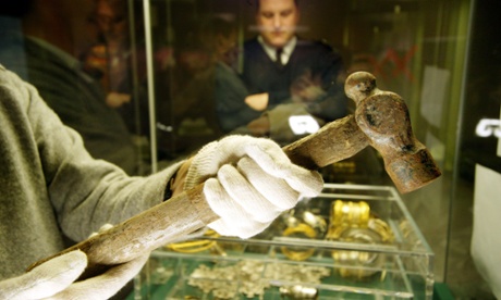 A British Museum staff member displays the lost hammer that Eric Lawes was searching for when he stumbled across the Hoxne hoard of Roman treasures in 1992.