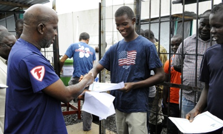 A man receives a certificate with a clean bill of health from the Elwa Ebola clinic in Monrovia.