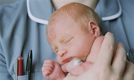 new born baby being held by midwife.