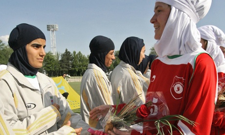 Players from Iran's women national football team exchange flowers with players from Germany's Al-Dersimspor team before a friendly match at Tehran's Ararat stadium 28 April 2006. Women football fans are prevented from attending games in the Islamic Republic.