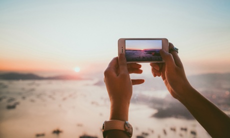 Taking photo of beautiful sunset with smartphone