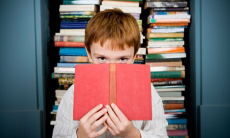 Boy peering over top of book