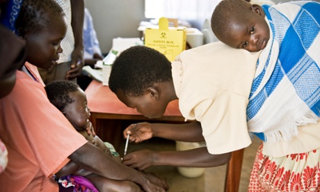Betty Acao, a newly trained community vaccinator, helps conducts an immunisation programme.