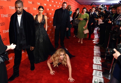 Schumer pretends to trip and fall on the floor in front of Kim Kardashian and Kanye West at the Time 100 Gala in New York.