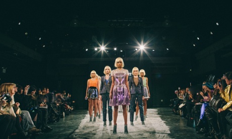 Models on a fashion catwalk wearing smart textile clothing lit by LEDs