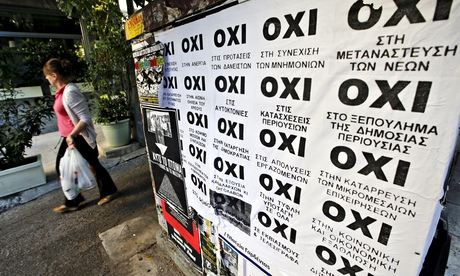 A woman in Athens walks past referendum campaign posters reading 