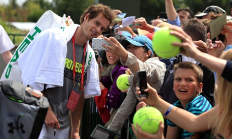 Andy Murray poses for selfies with fans following a training session on day seven of the Wimbledon Championships.