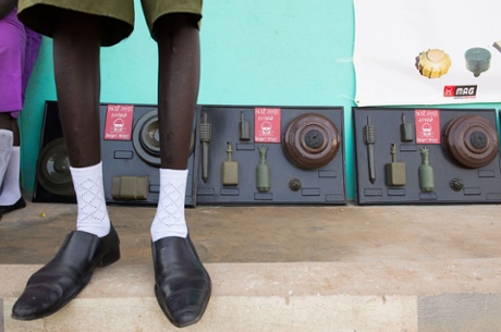 During a mine awareness initiative, a student stands in front of a cast of landmines in Juba, April 2014. 