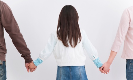 young girl holding hands with adults