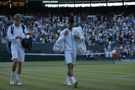 Novak Djokovic and Kevin Anderson walk off court. They will return tomorrow for a one-set shootout to reach the last eight.