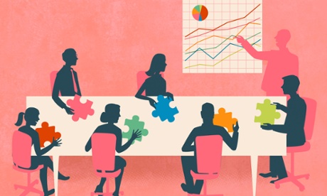 people sitting around a table with puzzle pieces