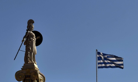 A statue of the ancient Greek goddess Athena stands next to a Greek flag in central Athens.