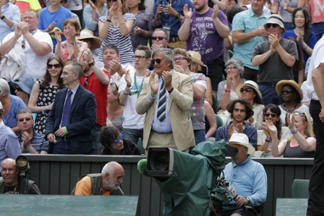The Centre Court crowd, including Stephen Fry, applaud her.