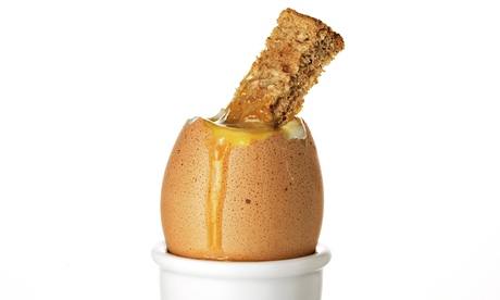 A boiled egg with a soldier dunked into it