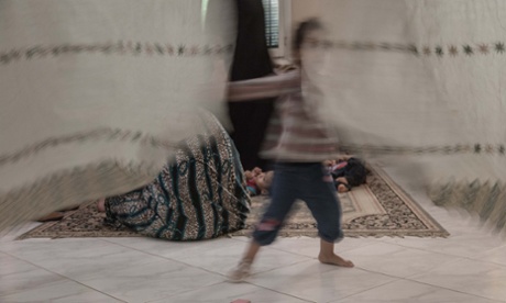 Play time: a girl behind a curtain at Hope Village. The centre is usually home to about a dozen teenage street mums and their kids.