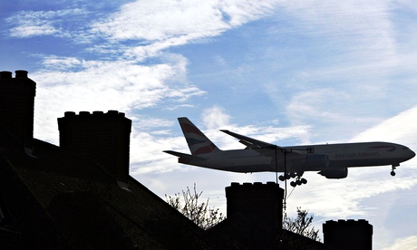 An aircraft flies just above a row of houses as it makes its final approach to Healthrow airport