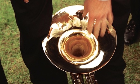 A youth orchestra brass player sets his gleaming instrument down during a break in the performance in Stevenage
