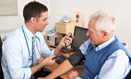 British doctor taking senior man's blood pressure