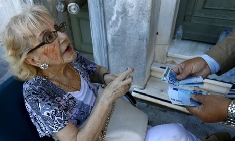 A woman receives her pension outside a bank in Athens.