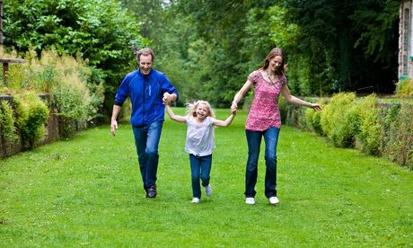 Two parents and their child in a garden