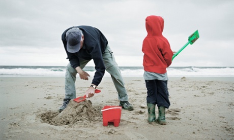 Grandfather and grandson build castle on the beach