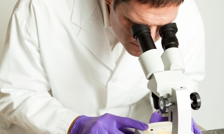 Forensic scientist looking at a blood sample under the microscope