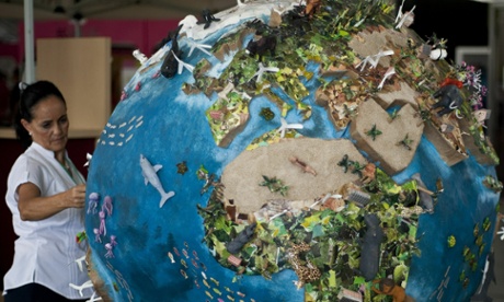 A woman looks at a globe model in the climate village during the United Nations Framework Convention on Climate Change (COP-16).