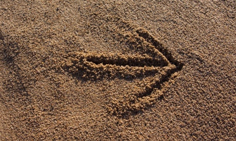 An arrow sign in the sand