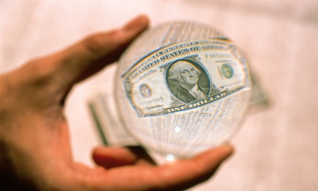 Hand holding magnifying glass over US dollar bill