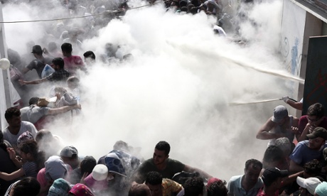 Police on Tuesday tried to disperse hundreds of migrants by spraying them with fire extinguishers during registration in the stadium.